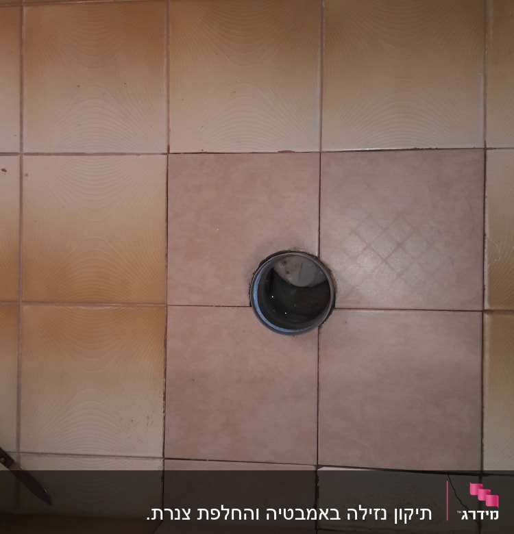 פתח ניקוז ברצפת אריחים חומים